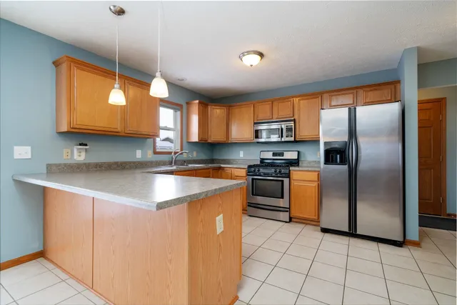 a kitchen with stainless steel appliances granite countertop a sink a stove and a refrigerator