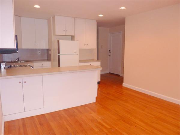 150 Beaconsfield Road, Unit 5 Brookline, MA 02445 - Photo 4 of 7 a kitchen with granite countertop white cabinets and refrigerator