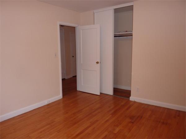 150 Beaconsfield Road, Unit 5 Brookline, MA 02445 - Photo 6 of 7 a view of an empty room with closet and wooden floor