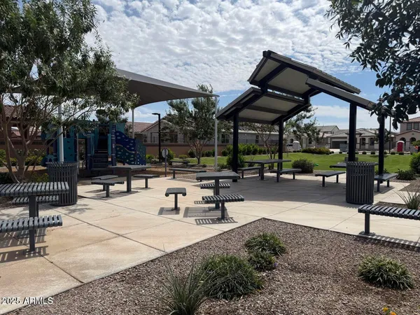 a view of a patio with a table and chairs under an umbrella with a small yard