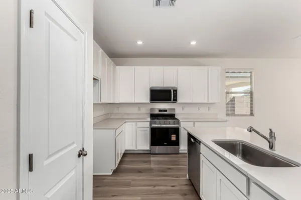 a kitchen with granite countertop white cabinets and white appliances