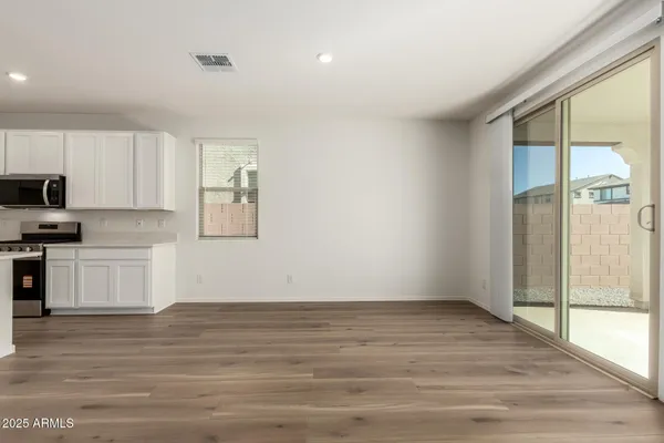 a view of a kitchen with wooden floor and electronic appliances