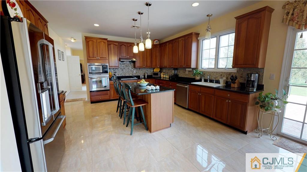 39 Zaitz Farm Road West Windsor, NJ 08550 - Photo 8 of 24 a kitchen with stainless steel appliances a refrigerator a sink a stove a microwave a dining table and chairs