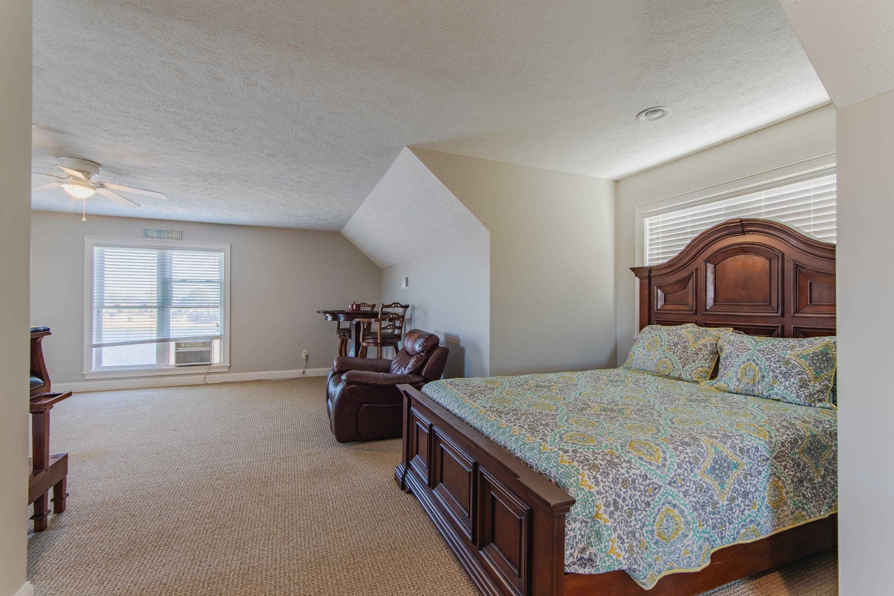1111 Leaning Trees Lane Adamsville, TN 38310 - Photo 18 of 36 Bedroom with a textured ceiling, light colored carpet, cooling unit, ceiling fan, and lofted ceiling