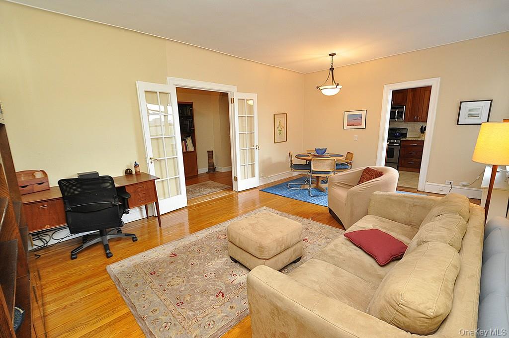 143 Garth Road, Unit 5J Scarsdale, NY 10583 - Photo 7 of 47 a living room with furniture and wooden floor