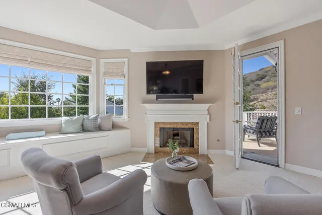 a living room with furniture a flat screen tv and a fireplace
