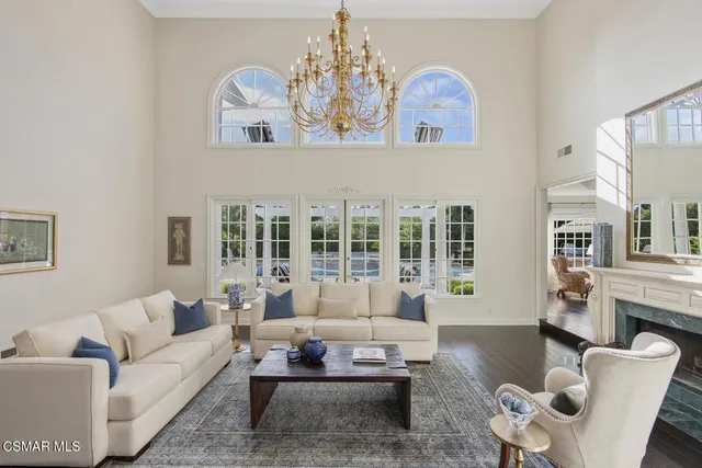 a living room with furniture fireplace and a large window