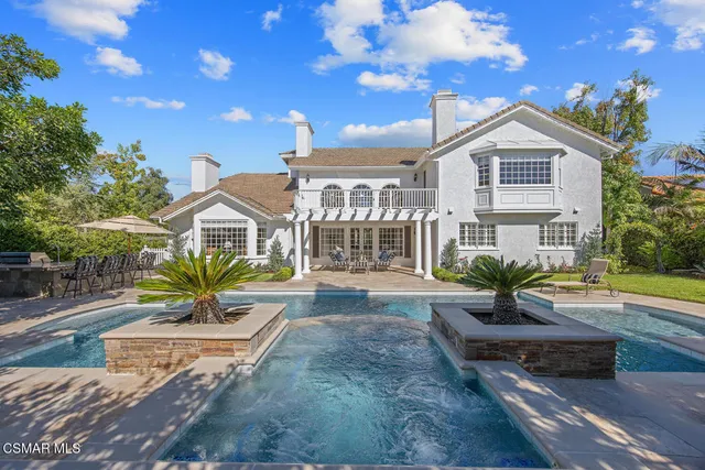 a front view of a house with a garden and plants
