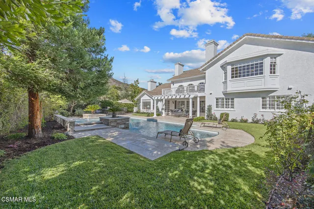 a view of a house with backyard and sitting area