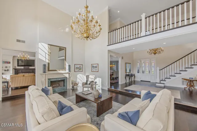a living room with furniture a chandelier and a fireplace