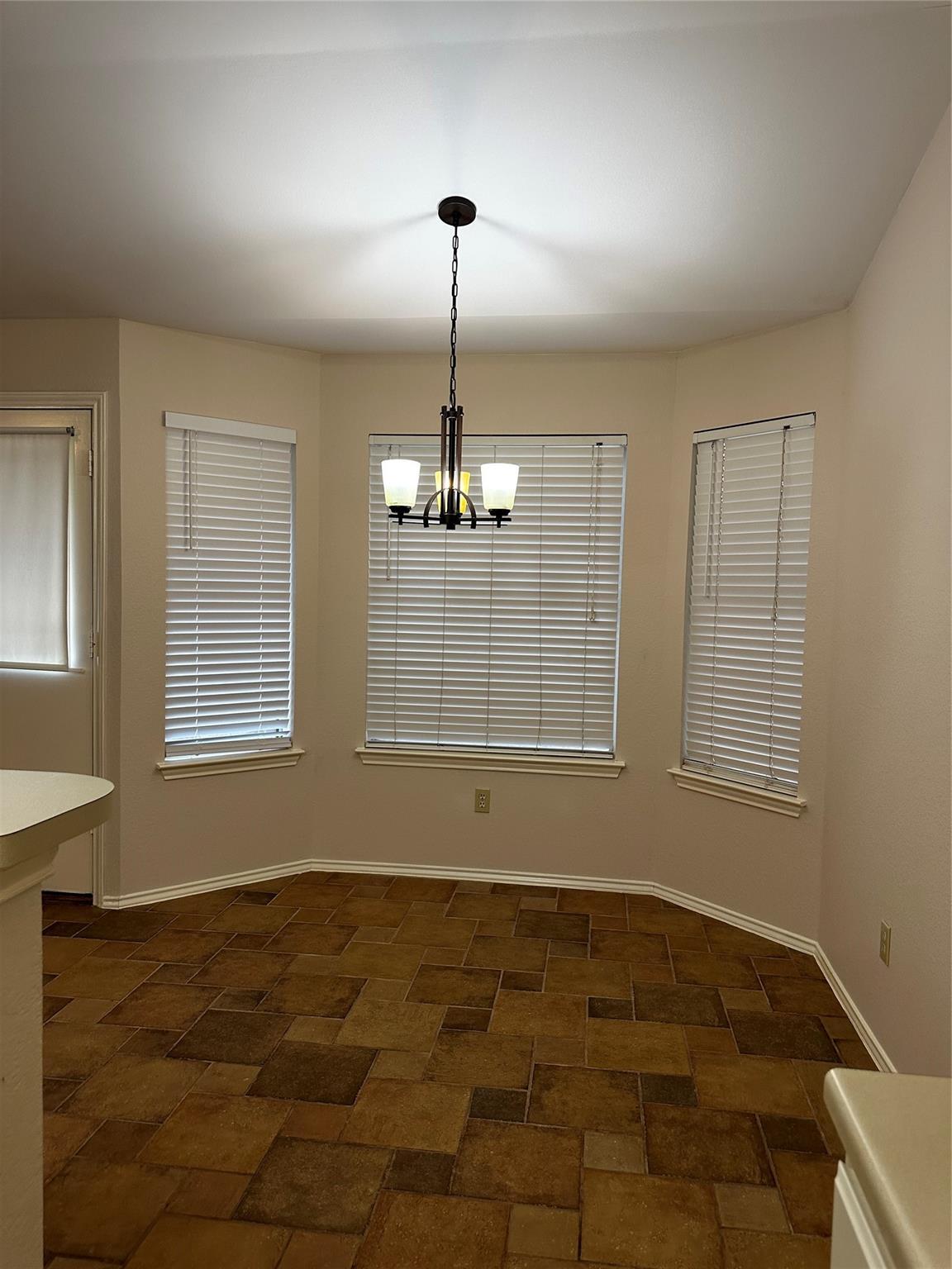 8007 Bounty Trail Austin, TX 78749 - Photo 11 of 32 Natural light floods this inviting dining area with a modern chandelier and durable tile flooring.