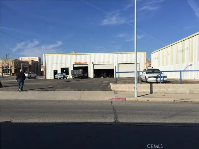 a living room with stainless steel appliances kitchen island granite countertop furniture and a fireplace