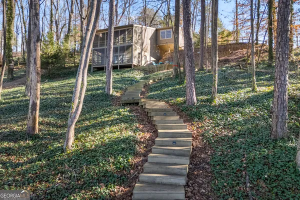a view of a house with backyard and trees