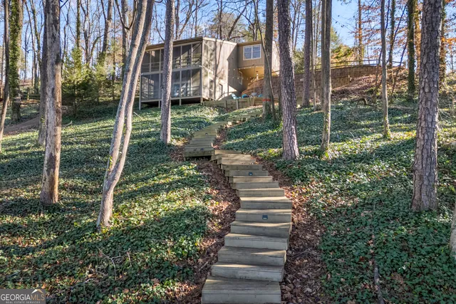 a view of a house with backyard and trees