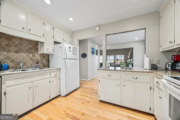 a kitchen with white cabinets and white appliances