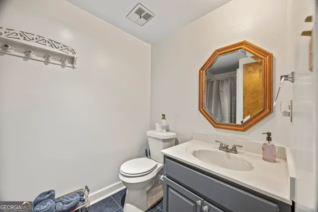 a bathroom with a toilet sink vanity and mirror