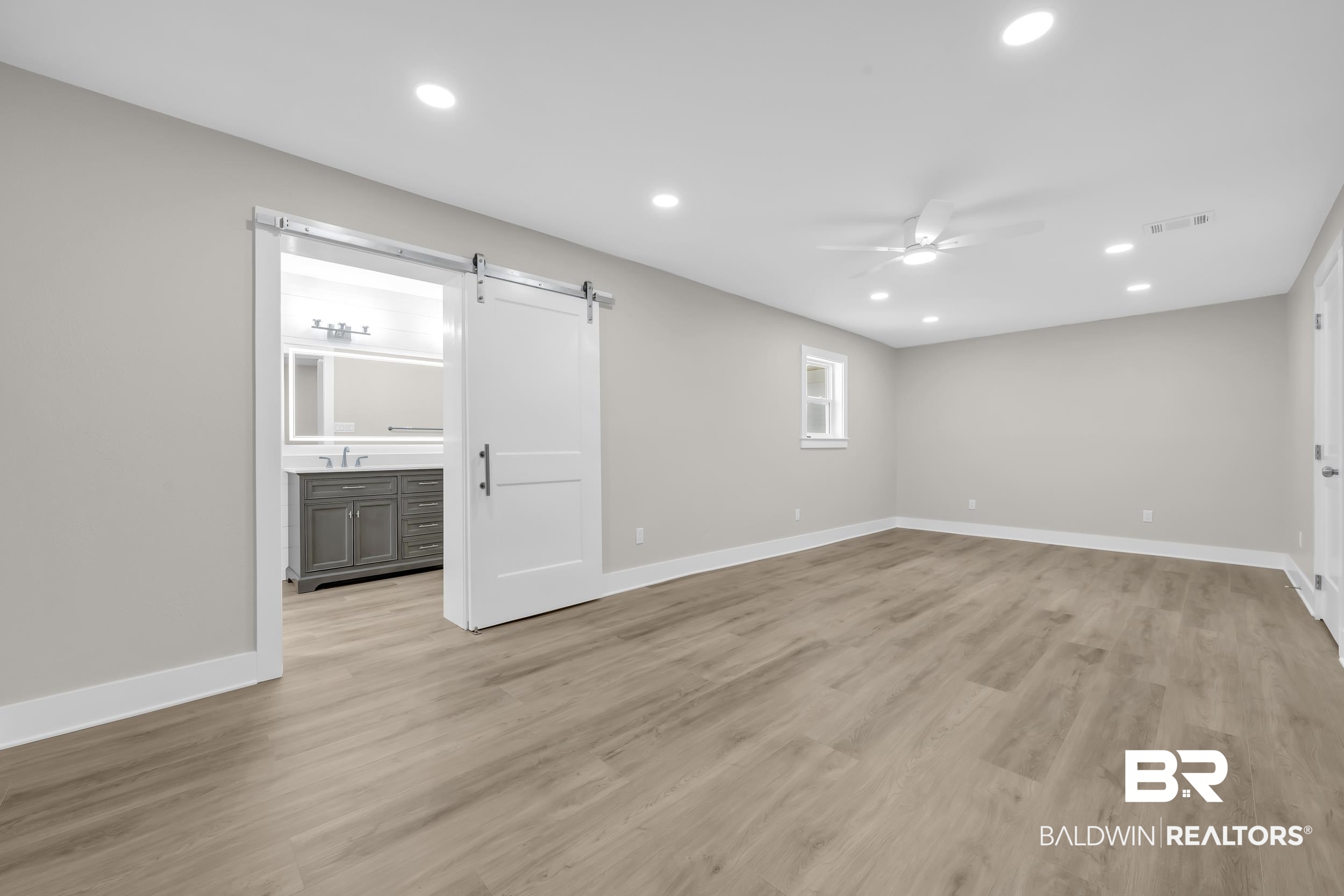 11381 Normandy Drive East Semmes, AL 36575 - Photo 9 of 23 Spare room featuring a barn door, a ceiling fan, recessed lighting, and light wood-style flooring