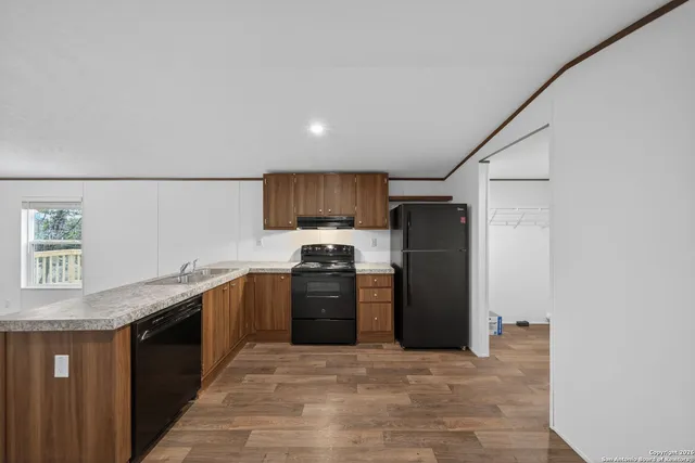 a kitchen with stainless steel appliances granite countertop a refrigerator a sink dishwasher a stove and a refrigerator