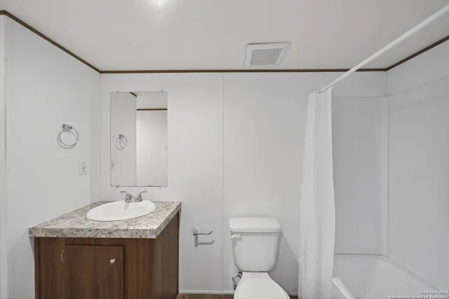 a bathroom with a granite countertop sink toilet and shower