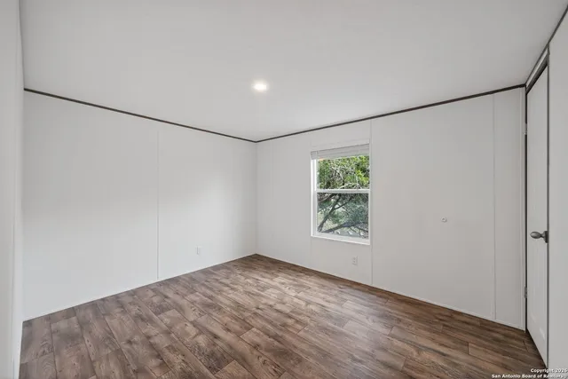 a view of a big room with wooden floor and windows