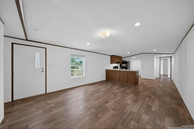 a view of a big room with wooden floor and windows