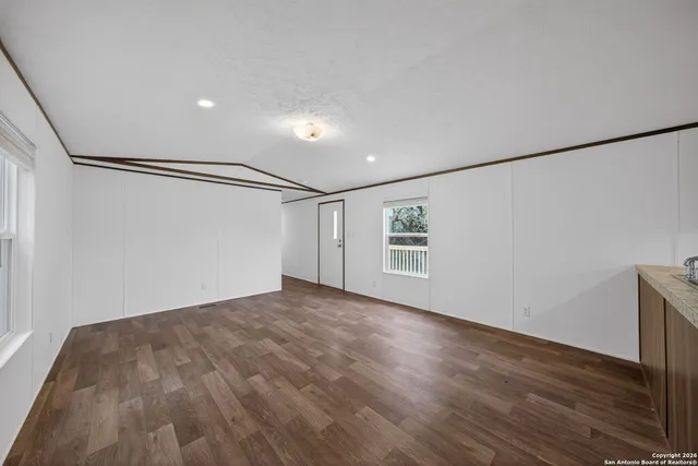 a view of empty room with wooden floor