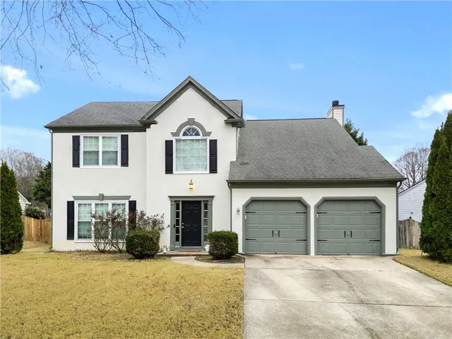 a front view of a house with a yard and garage
