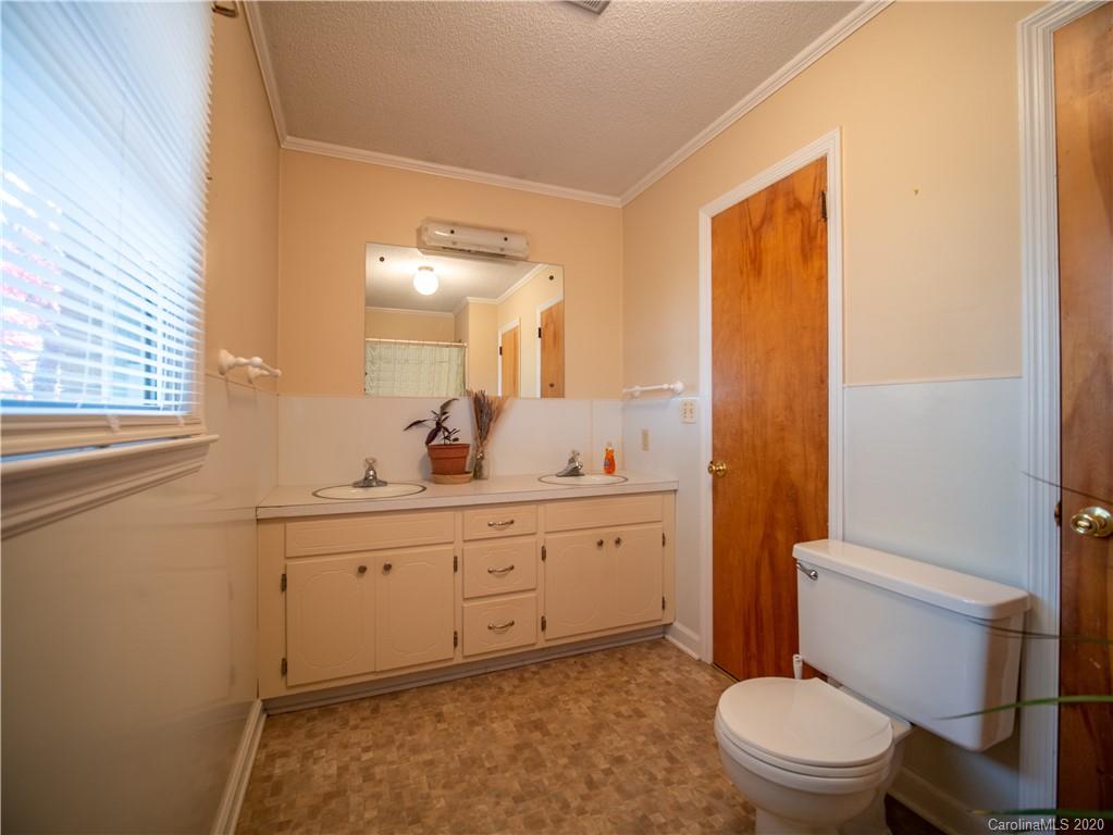 1956 Tradesville Road Lancaster, SC 29720 - Photo 7 of 18 a bathroom with a toilet a sink a mirror a window and vanity