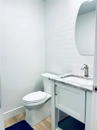 a bathroom with a granite countertop toilet sink and mirror