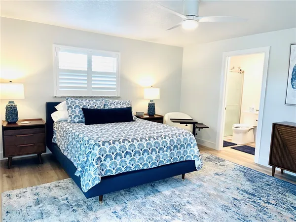 a bedroom with a bed and wooden floor