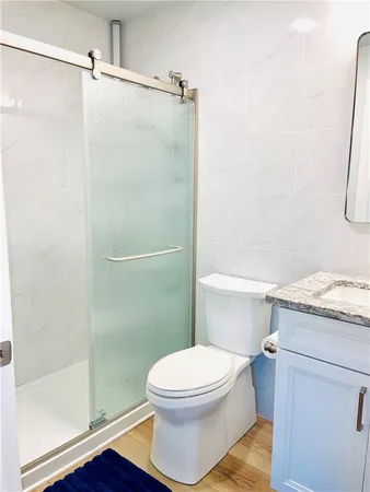 a bathroom with a granite countertop toilet and a shower