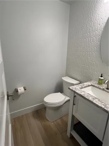 a bathroom with a granite countertop toilet and a sink