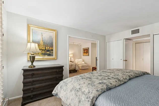 a bedroom with a bed and dresser with mirror