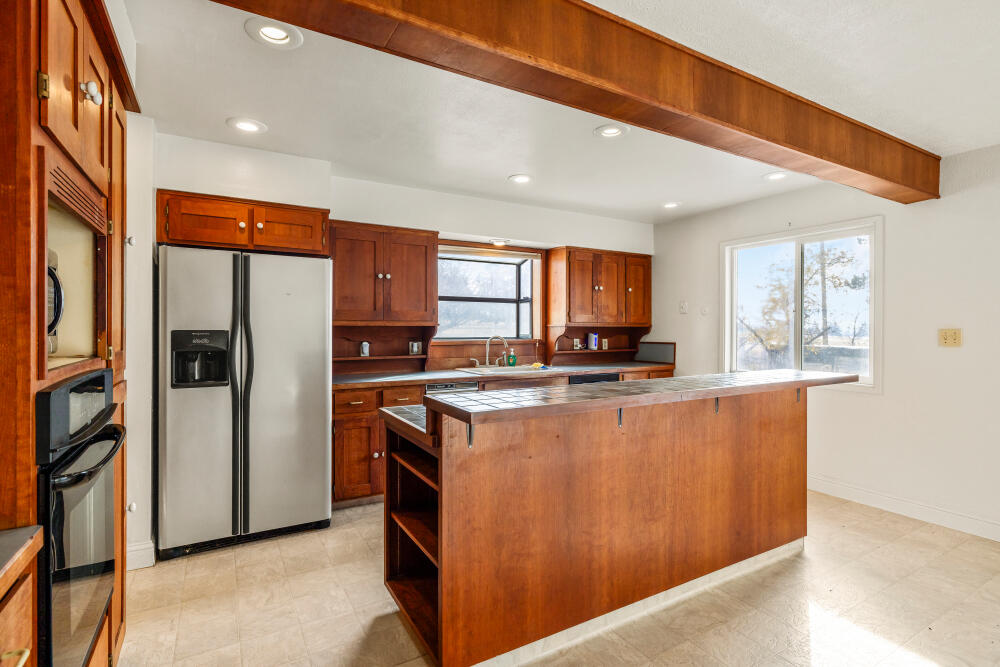 23131 North Poe Valley Road Klamath Falls, OR 97603 - Photo 13 of 45 a kitchen with stainless steel appliances granite countertop a refrigerator a sink a stove and wooden cabinets