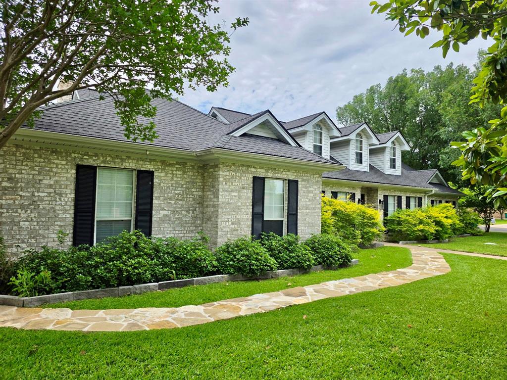 520 Red River Road Belton, TX 76513 - Photo 5 of 36 Brick exterior with contrasting dark shutters, a stone pathway, and dormer windows