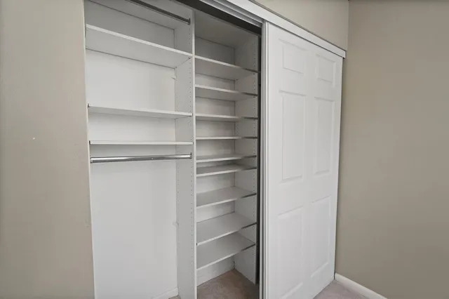 a view of walk in closet with empty racks