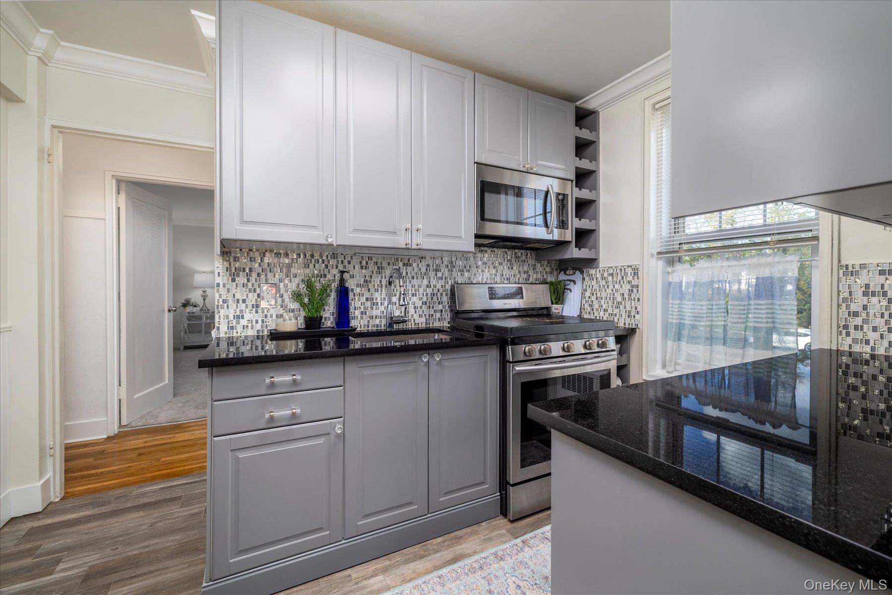 194 Smith Street, Unit 1K Freeport, NY 11520 - Photo 11 of 18 a kitchen with stainless steel appliances granite countertop a stove and a sink