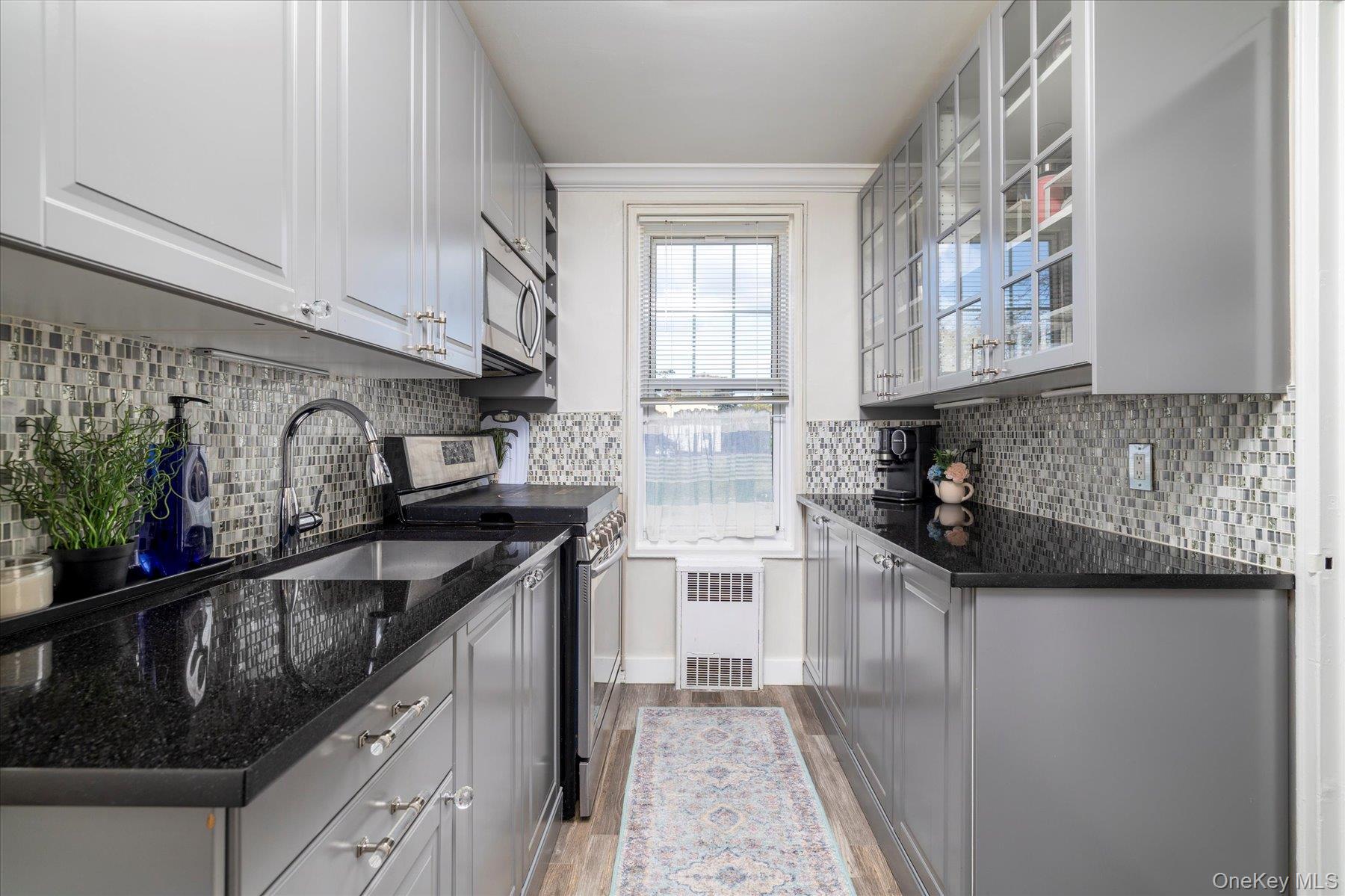 194 Smith Street, Unit 1K Freeport, NY 11520 - Photo 12 of 18 a kitchen with granite countertop a sink stove and cabinets