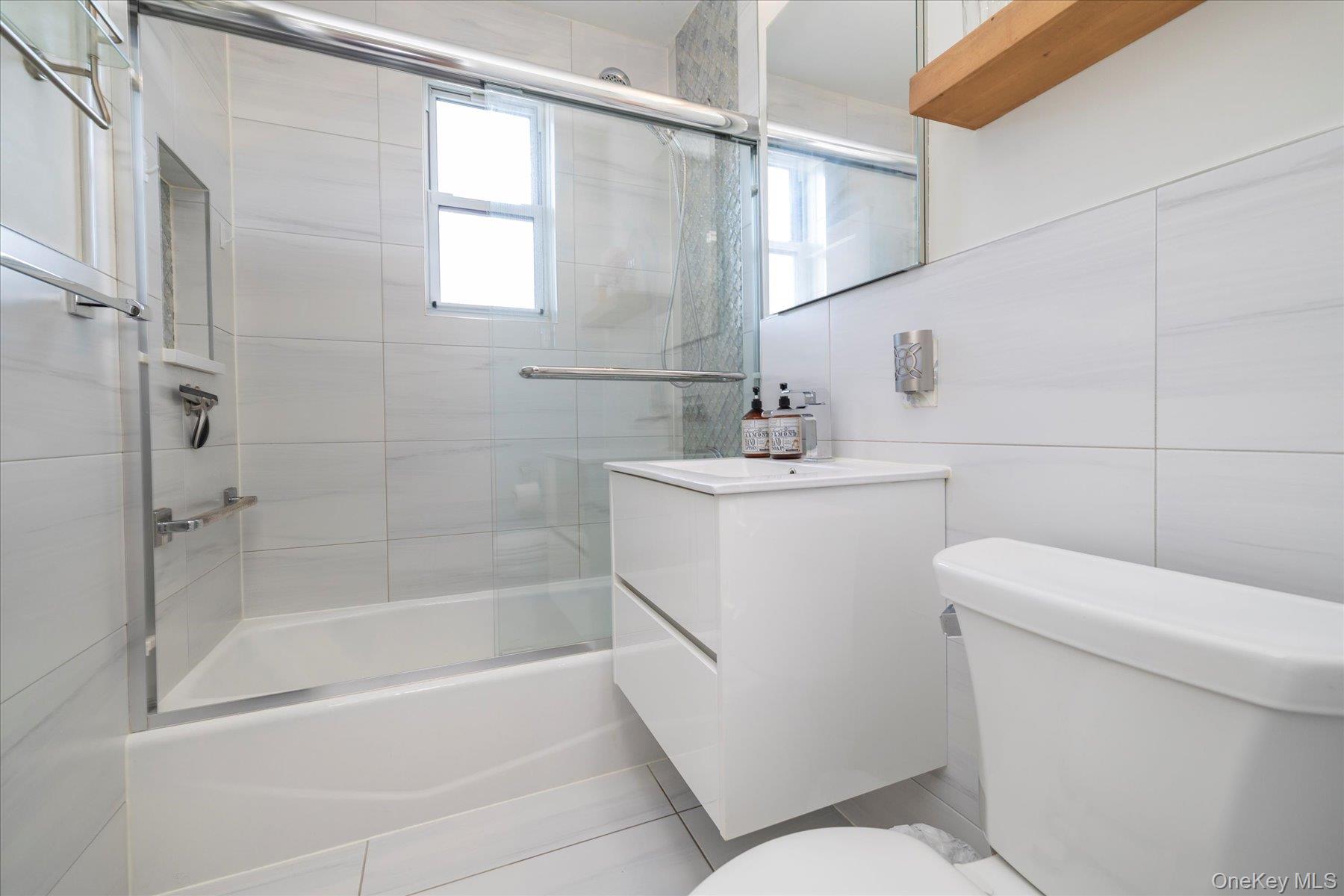 194 Smith Street, Unit 1K Freeport, NY 11520 - Photo 15 of 18 a bathroom with a sink a toilet and shower