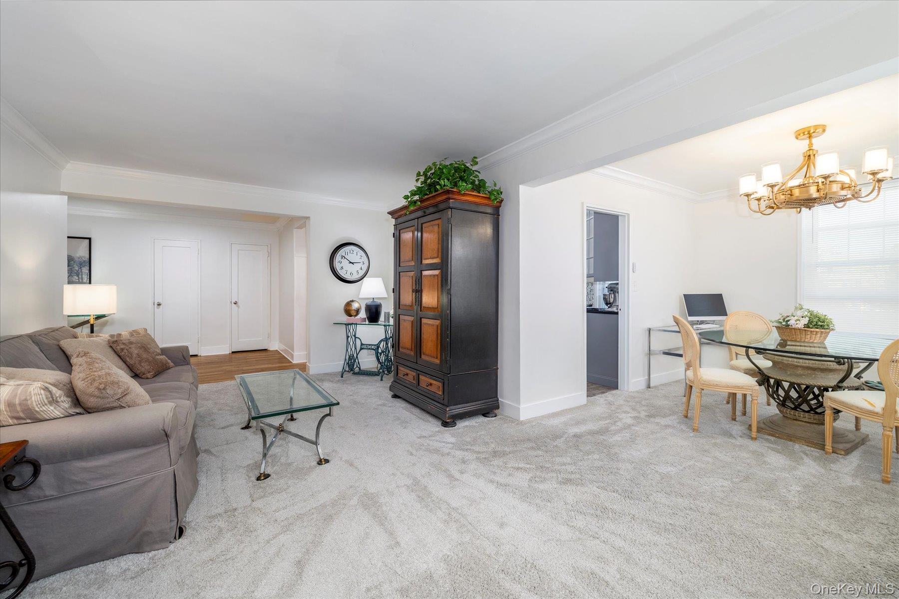 194 Smith Street, Unit 1K Freeport, NY 11520 - Photo 8 of 18 a living room with furniture and a chandelier