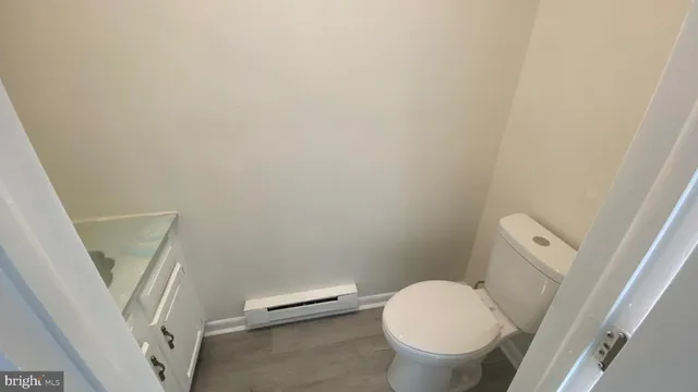 a white toilet sitting next to a wooden floor