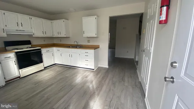 a kitchen with wooden floors and white appliances