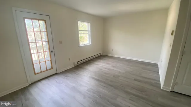 an empty room with wooden floor and windows
