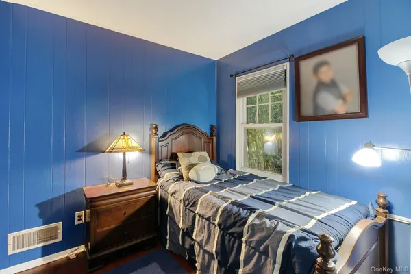 a bedroom with a bed and a lamp with wooden floor
