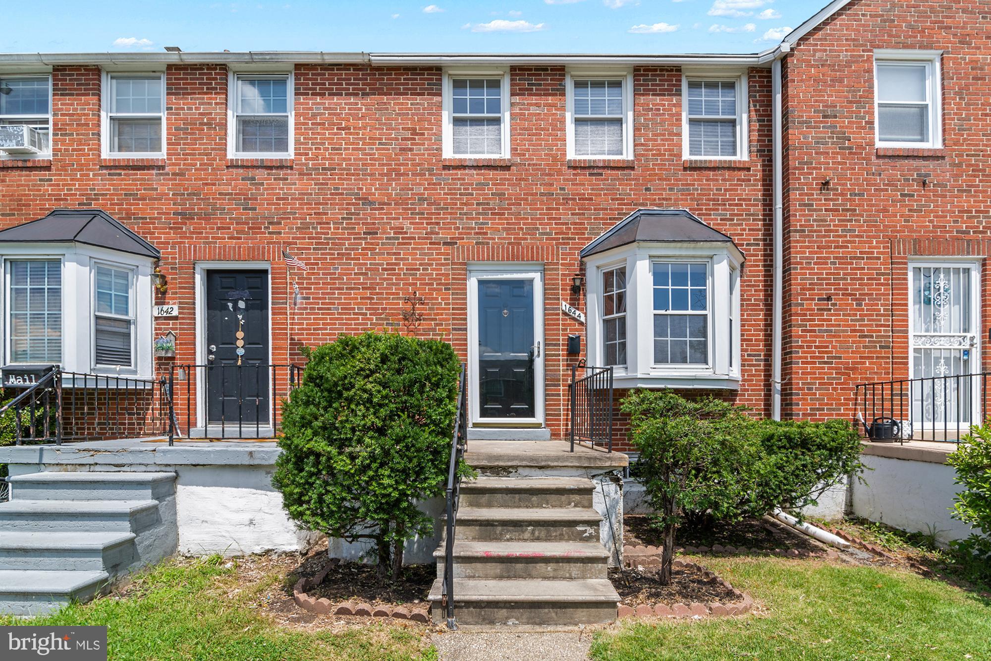 a front view of a house with plants and garden
