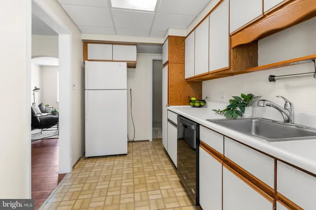 a kitchen with granite countertop a sink a stove a refrigerator and a cabinets