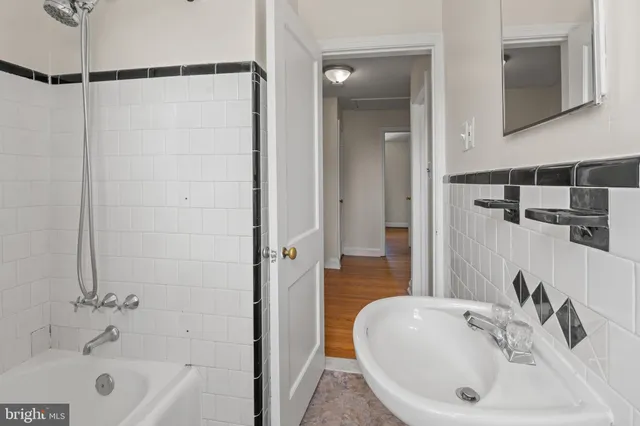 a bathroom with a sink a toilet a window and shower