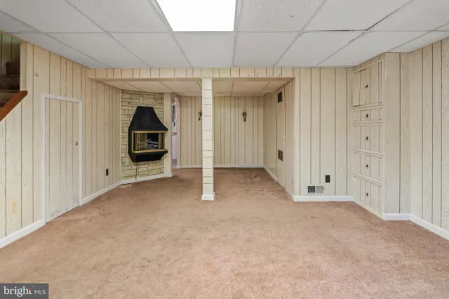 a view of a hallway with wooden floor and a bathroom