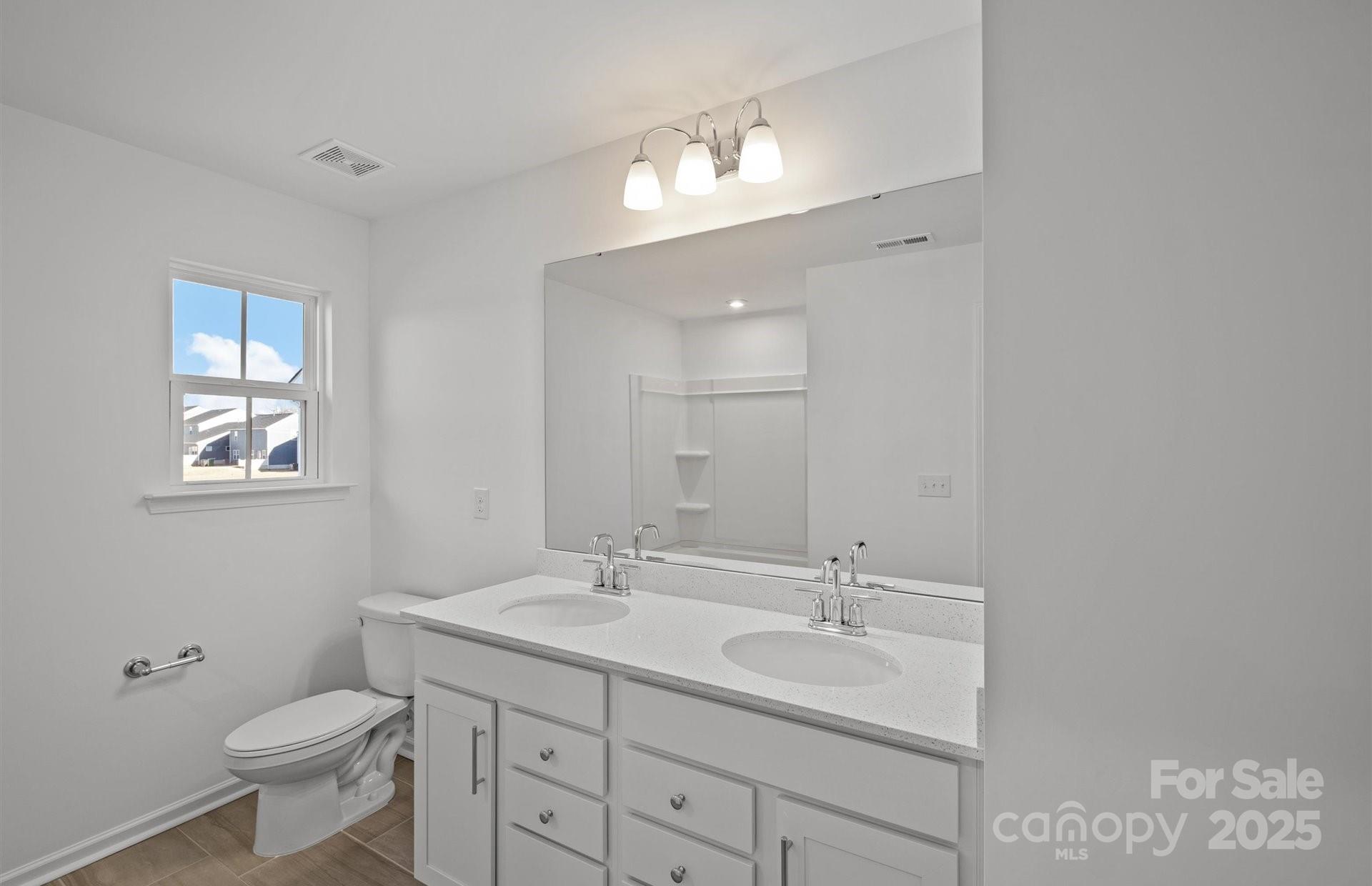 11416 Glasden Road, Unit 511 Charlotte, NC 28278 - Photo 11 of 13 a bathroom with a toilet sink and mirror