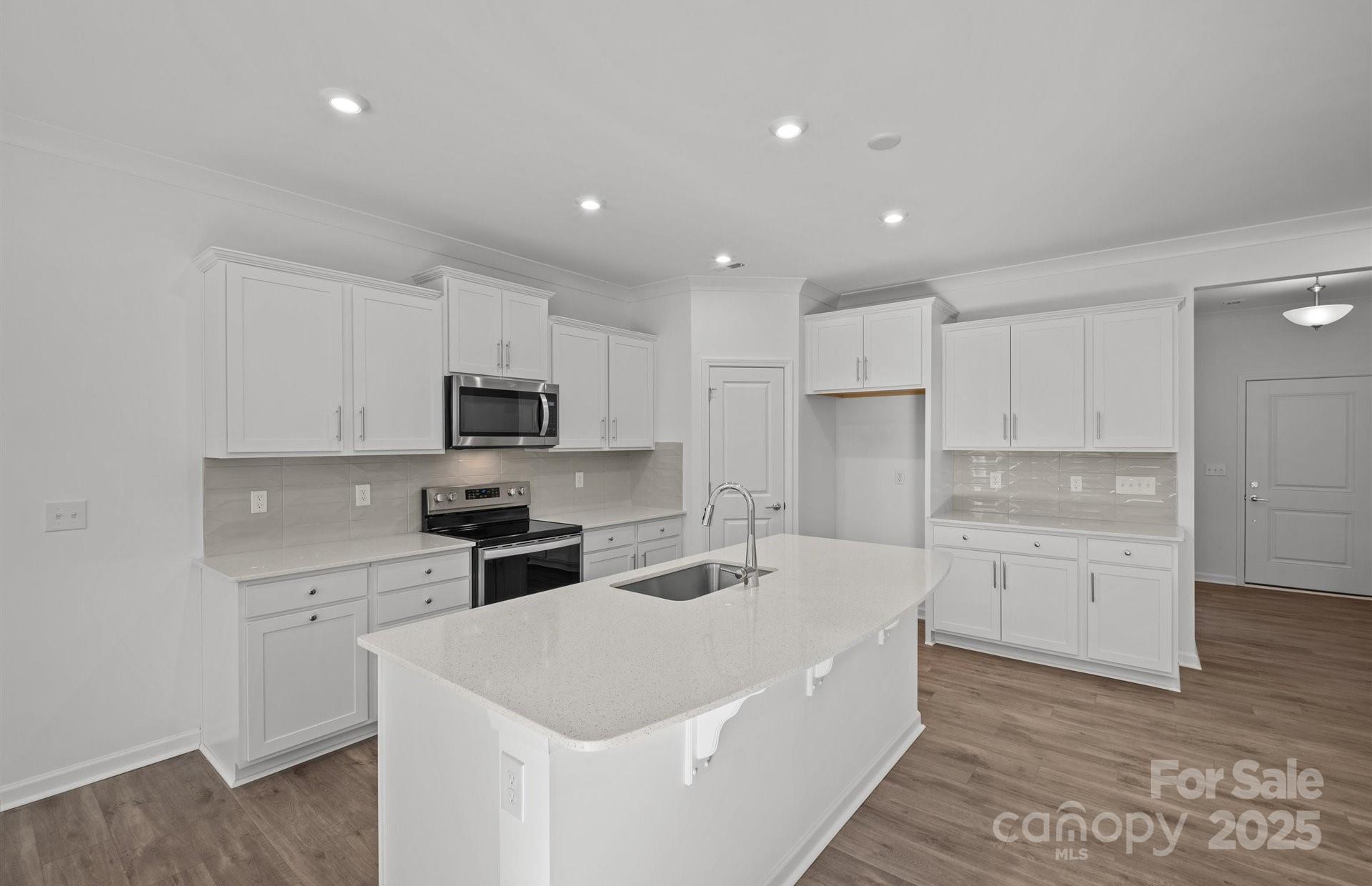 11416 Glasden Road, Unit 511 Charlotte, NC 28278 - Photo 4 of 13 a kitchen with white cabinets and stainless steel appliances
